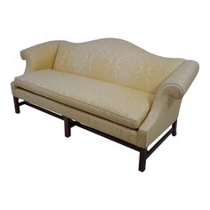 a cream colored couch sitting on top of a wooden frame