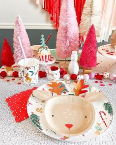 a table topped with plates and cups filled with christmas decorations