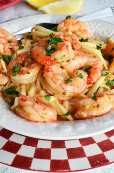 pasta with shrimp and parsley in a white bowl on a checkered tablecloth