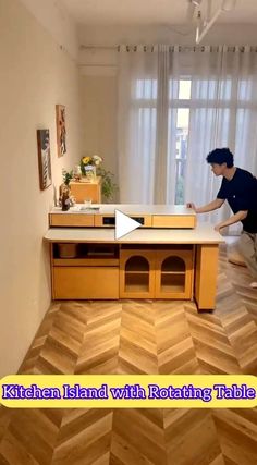 a man standing on top of a wooden table in front of a tv screen with the words kitchen island with rotating tabletop