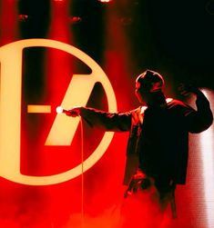 a man holding a microphone in front of a red and white sign that says adobe