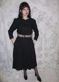 "80s - 90s black dress by Lanz originals. Has pockets at each hip and a lovely floral tapestry belt that attaches with a button in front. Has puff sleeves and a bit of a v-neck in front. Has general vintage wear but overall looks good and is ready to wear!  Size marked: 12 -- see measurements to ensure fit. For reference the model wears approximately a modern size Medium in Women's and is 5'9\". All measurements are in inches and are taken of the item laid flat and not doubled.  Shoulders: 15.5 Across armpits: 18.5 Waist: 12-16 Hips: 26 Arms: 19.5 Length: 46.5 Follow @lunarhovel on instagram for new items posted every week and sale announcements! International customers - I will not mark items as a gift on the customs form - this is illegal and puts the seller at risk. You are responsible Modest Goth, 90s Black Dress, Floral Tapestry, Beautiful Boots, Dress With Pockets, Vintage Wear, Dress Clothes For Women, Puff Sleeves, Puff Sleeve