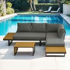 a couch and coffee table sitting in front of a swimming pool with chaise lounges