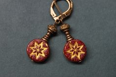 "Very feminine and pretty dangle earrings made with dark red Czech glass beads featuring a star in a gold wash. Adorned with antique brass findings which give to these earrings an antique rustic look. They hang from brass lever backs ( lead and nickel free ). Leverbacks keep your earrings on securely by creating a closed loop. They're light and small in length. They combine simplicity and charm to fit any casual or formal event and will be perfect to wear during Christmas Holidays ! Color : tran Handmade Burgundy Earrings For Gift, Vintage Red Earrings For Festive Occasions, Red Beaded Drop Earrings, Pierced, Vintage Red Beaded Earrings For Gift, Vintage Red Beaded Earrings As Gift, Handmade Vintage Red Beaded Earrings, Elegant Red Czech Glass Earrings, Red Earrings With Lever Back Ear Wires For Gift, Red Earrings With Lever Back For Gift