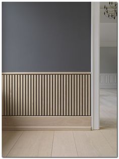 an empty room with wood paneling on the wall and wooden floor in front of it