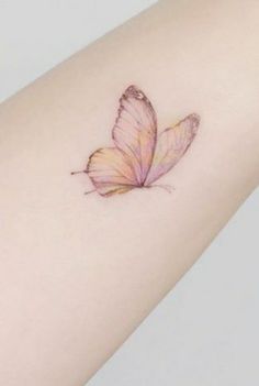 a small pink butterfly tattoo on the arm