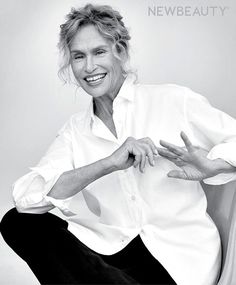 a black and white photo of a woman sitting in a chair with her hands on her hips