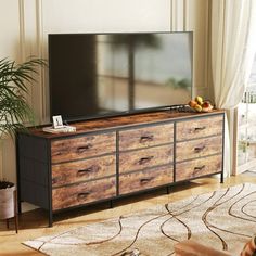 a living room scene with focus on the dresser and television set in the background,