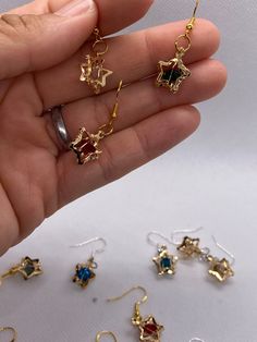 🔹These beautiful 3D star earrings are small and perfect to enhance your look at any time. The earrings are made using hypoallergenic hooks, which are colored silver or gold (randomly selected). The measurements are around 1/2  to 1 inch, including the hook.  🔹You can choose from the colors below:            clear             turquoise             candy apple star             yellowish             🛑 Please be aware that I do not accept cancelations or returns since I am preparing the earrings Metal Drop Earrings With Star Charm, Gold Star-shaped Crystal Earrings For Party, Single Star-shaped Crystal Earring As Gift, Nickel-free Star-shaped Earrings For Jewelry Making, Gold Star Earrings With Ear Wire, Star-shaped Earrings For Pierced Ears As A Gift, Gold Star-shaped Earrings With Ear Wire, Metal Earrings With Star Charm For Gift, Star-shaped Crystal Earrings For Gifts