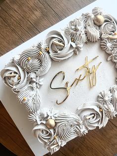 a white card with gold lettering on it and some flowers in the shape of swirls