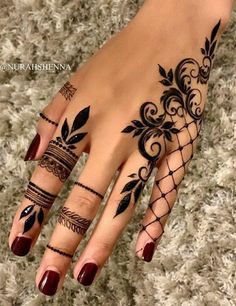 a woman's hand with hennap tattoos on her fingers and hands,