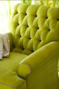 an image of a green chair with white pillows on the armrests and back