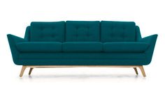 a blue couch sitting on top of a white floor next to a wooden leg chair