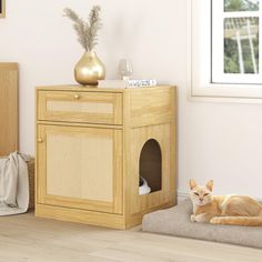 an orange cat laying on top of a bed next to a wooden cabinet