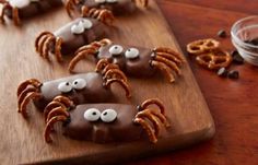 chocolate covered pretzels with googly eyes on a cutting board