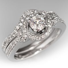 a white gold diamond engagement ring with matching wedding bands and an intricate halo style band