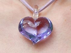 This exquisite Venetian lilac purple 3D glass heart pendant would make a perfect present. Due to its semi-translucent and reflective qualities, this beautiful pendant can display varying shades of lilac in different light conditions. Width: approximately 32mm Drop: approximately 40mm including glass bail The pendant is finished with approximately 90cm of lilac faux suede lace, adjustable to length desired.  Organza ribbon is also available in silver or white if preferred. Please specify at check Purple Double Heart Charm Jewelry, Purple Double Heart Jewelry With Heart Charm, Glass Heart Pendant Necklace For Gift, Handmade Purple Heart-shaped Jewelry, Clear Glass Heart-shaped Jewelry, Handmade Heart-shaped Purple Jewelry, Purple Heart Pendant Necklace For Jewelry Making, Clear Heart Pendant Jewelry Gift, Clear Heart Pendant Jewelry As Gift