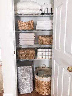 an organized closet with baskets and towels