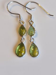 Sterling silver drop peridot  dangle  earrings with AAA green crystals handmade with care.   High quality materials, long-lasting and very sparkly.  Perfect gift for women and girls, makes an ideal stocking filler, Valentine's Day gift, Mother's Day gift, Anniversary gift and birthday gift, these earrings come gift wrapped. Some believe peridot  is derived from the Arabic faridat, meaning "gem," or from the Greek word, peridona, which means "give in abundance." Given its resemblance to the colou Long Green Earrings, Green And Silver Jewellery, Green Peridot Earrings For Anniversary, Peridot Earrings For May Birthstone Gift, Peridot Drop Earrings For May Birthstone, May Birthstone Drop Earrings, Green Peridot Drop Earrings, Green Drop Jewelry For Jewelry Making, Peridot Gemstone Dangle Jewelry