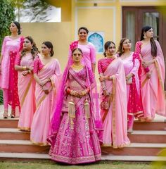 a group of women in pink dresses standing on steps