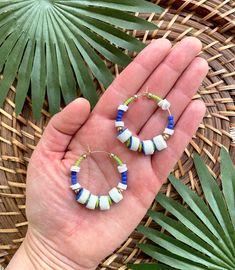 Want to save 15% off your first purchase? Sign up for my email list to receive an instant coupon code! http://eepurl.com/dvS75L This listing is for 35mm gold filled beaded wire hoops featuring blue and white African Sandcast Glass beads, matte cobalt blue and lime green African seed beads, brass spacer beads, and lime green vinyl heishi beads. These earrings are semi-lightweight and should be suitable if you have sensitive ears. If you are not satisfied with your earrings for any reason, please Blue Beaded Hoop Earrings For Summer, Blue Hoop Earrings With Ear Wire For Beach, Blue Small Hoop Beaded Earrings For Summer, Blue Hoop Jewelry For The Beach, Beach Jewelry Small Hoop With Colorful Beads, Blue Beaded Hoop Earrings For The Beach, Handmade Blue Heishi Beads Earrings, Handmade Beaded Hoop Earrings For Beach, Handmade Hoop Beaded Earrings For Beach