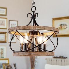 a chandelier hanging from a ceiling in a room with pictures on the wall