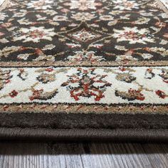 a brown and white rug on top of a wooden floor