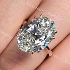 a close up view of a diamond ring on someone's finger, with the center stone