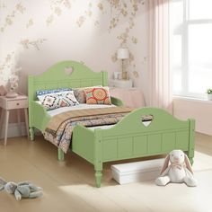 a child's bedroom with pink walls and green furniture