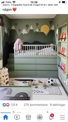 the baby's room is decorated in green and white with mountains on the wall