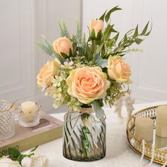 a vase filled with lots of flowers on top of a table next to some candles