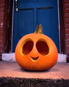 an orange pumpkin with two holes in it's face sitting on the front steps