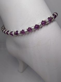 This durable bracelet or anklet is made on stainless steel accuflex wire and consists of 5mm Swarovski Crystal Amethyst 5mm bicone and silver-plated pewter rondel beads.   The lobster claw clasp is made up of steel, pewter, and silver-plated pieces.Sizes - Bracelet:Small 6"Medium 7"Large 8"Sizes-Anklet:Small 9-9 ½”Medium 10-10 ½”Large 11-11 ½”Anklets can also be made for in-between sizes if you let me know the exact length you would like.The best way to find your size is to measure your ankle, a Adjustable Purple Anklets As Gift, Handmade Purple Anklets As Gift, Adjustable Purple Metal Crystal Bracelet, Adjustable Crystal Anklets As Gift, Adjustable Nickel-free Crystal Bracelet, Crystal Amethyst, Stainless Steel Wire, Amethyst Crystal, 11 11