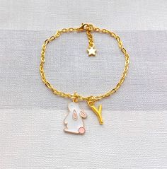 Super cute rabbit charm bracelet perfect for any bunny lover. Great little gift for easter. Perfect when ordered with my matching items that are in my store. *You can select the size required from the drop down menu. *The enamel charm measures approximately 2cms long and is available in pink, white and blue. *The charm, chain and other findings are gold plated. *These can also be personalised with initial charms which can be picked from the menu. ☆☆The bracelet comes presented in a gift bag but gift messages and  wrapping can also be purchased from my store.☆☆ If you have any questions or custom orders please feel free to message me. Cute Dangle Charm Bracelet, Cute Dangle Charm Bracelet With Lobster Clasp, White Kawaii Charm Bracelet Gift, Adjustable Jewelry With Cute Design Gift, Handmade White Kawaii Charm Bracelet, Playful White Bracelet With Charms, Whimsical Gold Charm Bracelet Gift, Gold Whimsical Charm Bracelet For Gift, Gold Whimsical Charm Bracelet Gift