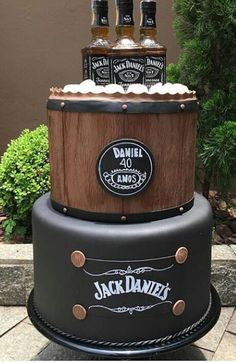 there is a cake made to look like a barrel with three bottles on top and the words jack daniels written on it