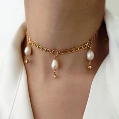 SCYLLA GOLD NECKLACE: ✦ This choker necklace is made of 3 white freshwater pearls decorated with zircons. Its original chain and large rings give it a romantic/goth look that can go with many outfits. COMPOSITION: ✦ Gold plated 18K stainless steel (waterproof) ✦ Freshwater pearls ✦ Zircons SIZE: ✦ Length: 33cm + 5cm chain extension JEWELLRY CARE: ✦ This jewel is made of stainless steel which makes it tarnish resistant and waterproof. Over time, the golden layer can acquire a slight patina.  In o Pearl White Metal Jewelry With Adjustable Chain, Elegant Metal Pearl Choker Necklace, Gold Pearl Choker With Adjustable Chain, Metal Pearl Charm Choker Necklace, Metal Pearl Drop Choker Necklace, Baroque Pearl Chain Choker, Pearl Choker With Chain Detail, White Metal Pearl Choker Necklace, Gold Metal Choker With Pearl Chain