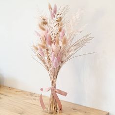 a bouquet of dried flowers sitting on top of a wooden table