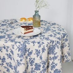 a table topped with a piece of cake and a vase filled with flowers on top of it