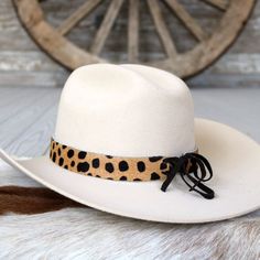 The Pebbles hat band is a stylish leather accessory featuring tan, hair-on cowhide, with dark brown spots. It measures 22.5" long and 1" wide. Adjustable leather ties ensure a perfect fit for almost any hat.    Length: 22.5 inches  Width: 1 inch  Adjustable Leather ties  Genuine Leather Adjustable Western Hat Bands For Fall, Adjustable Country Hat Bands For Fall, Adjustable Brown Leather Hat Bands, White Adjustable Leather Hat, Adjustable White Leather Hat, Adjustable Leather Hat For Fall, Adjustable Leather Fall Hats, Adjustable Leather Felt Hat For Western-themed Events, Adjustable Western Leather Felt Hat