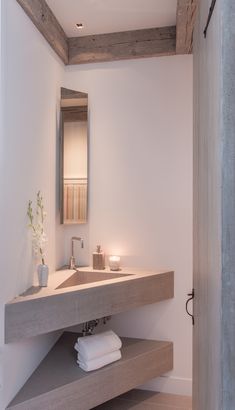 a bathroom with a sink, mirror and towel rack in it's center area