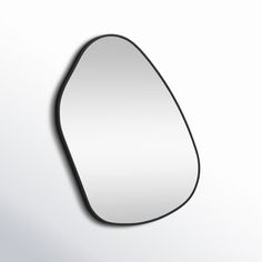 an oval shaped mirror on a white wall with black trimmings and a shadow