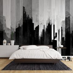 a bedroom with black and white paint on the wall, wood flooring and bed