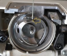 the bottom part of a machine with an arrow pointing to it's center wheel