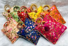 six different colors of clutches and purses on a white furnishce background, all with beaded details