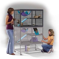 a woman and girl petting two cats in a cage