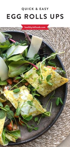 an egg rolls up on top of a plate with greens and other food in it