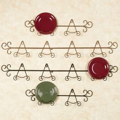 a set of four metal wall hooks with red and green plates on them