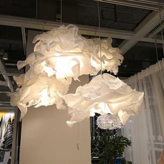 a chandelier hanging from the ceiling with white fabric on it's arms