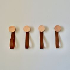 five wooden spoons are lined up in a row on the wall next to each other