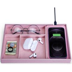 a pink tray with various items in it and a phone on the other side,